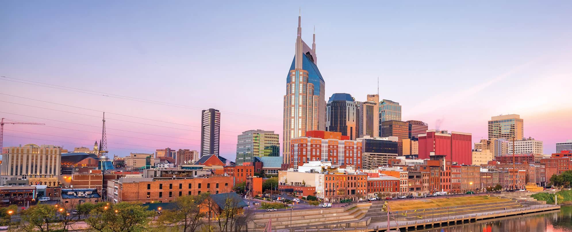 The city skyline and Cumberland Park at dusk along the Nashville, Tennessee riverfront.