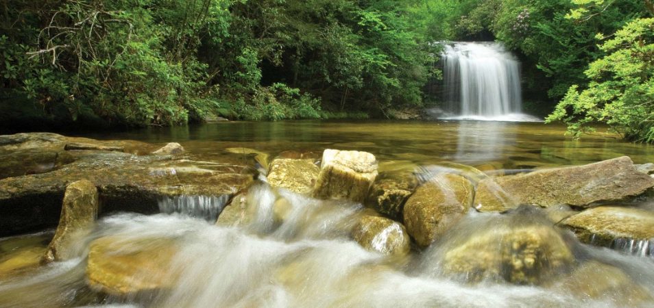 A waterfall streams through the river rocks on a national park vacation