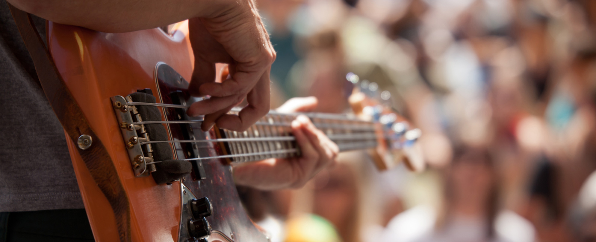 A musician strumming a base guitar