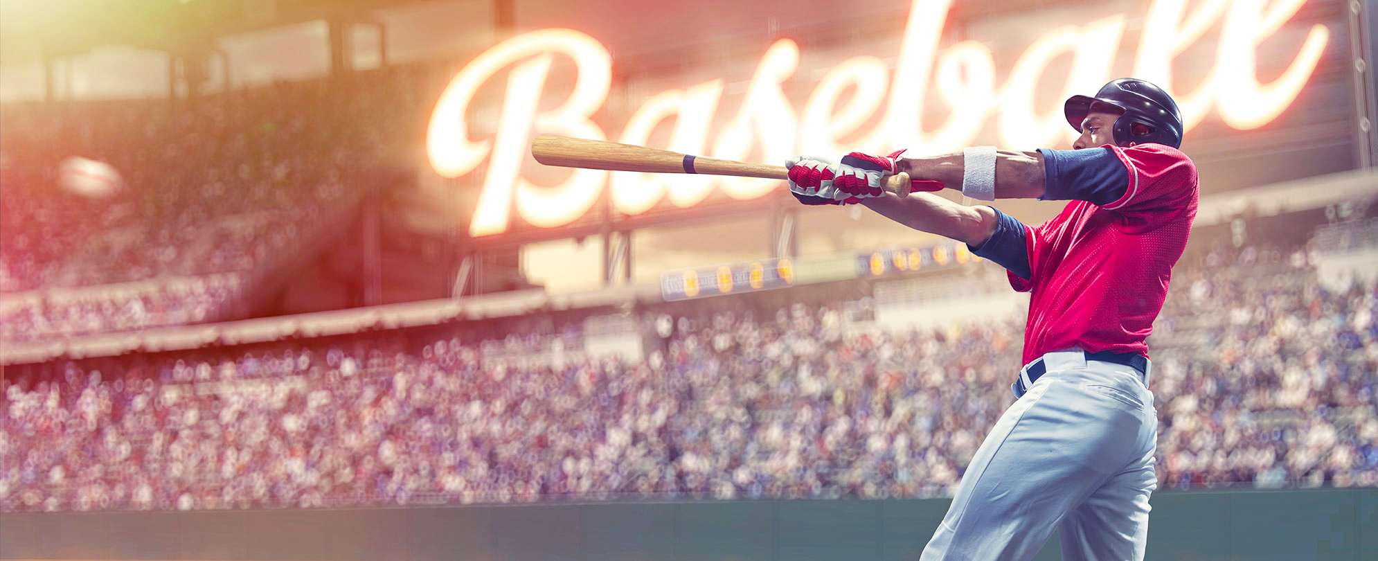 A baseball player hitting a baseball in a crowded stadium with a neon sign that reads ‘Baseball’