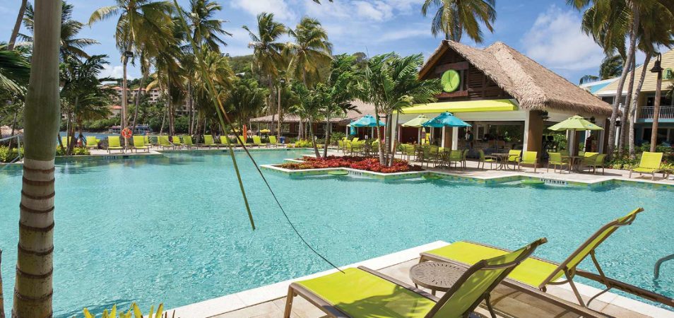 Bright green pool chairs and palms surround the pool and tiki bar of Margaritaville Vacation Club by Wyndham - St. Thomas.