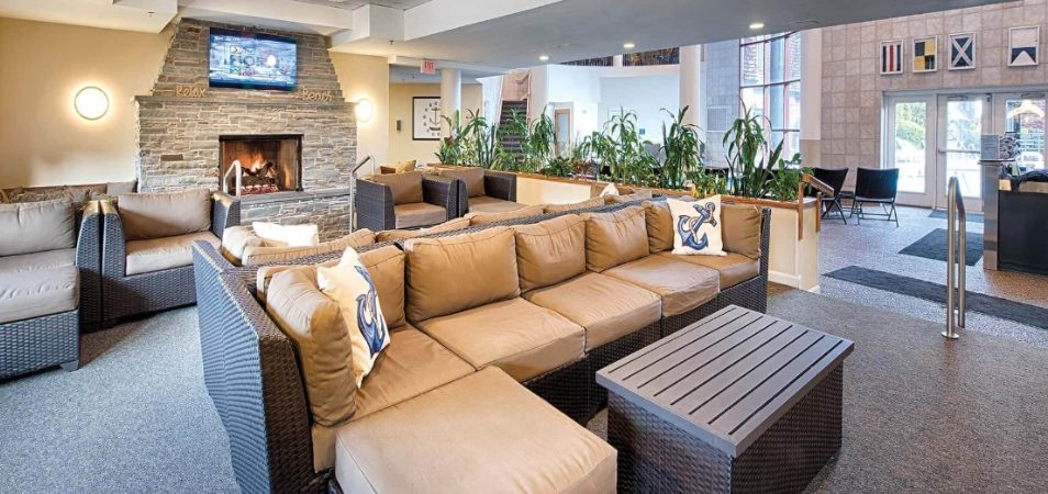 Wicker couches with tan cushions and fireplace in a Margaritaville Vacation Club by Wyndham resort lobby.