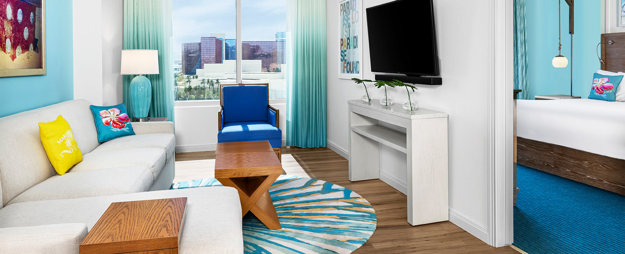 A bright and colorful bedroom and living room at Margaritaville Vacation Club by Wyndham - Desert Blue in Las Vegas, NV.